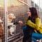 A young woman engages with four rescue dogs and an animal shelter worker stands next to metal dog kennels.